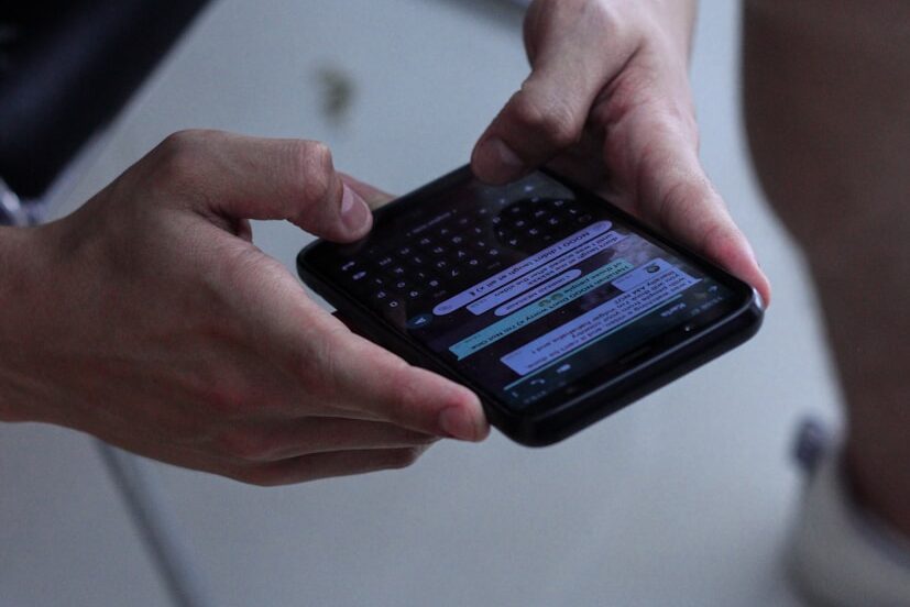 Close-up of person holding two smartphones, symbolizing modern communication trends.